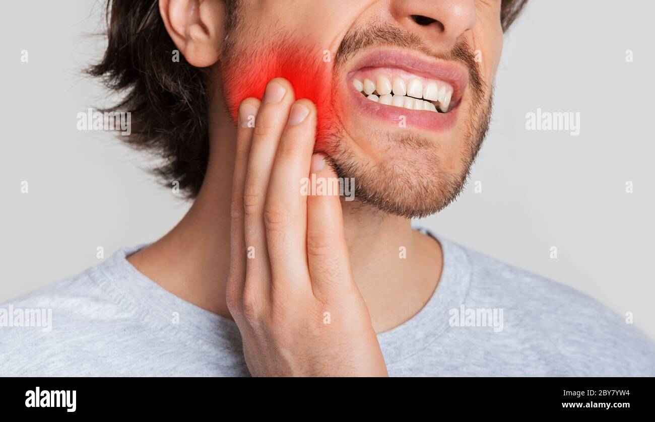 Tooth and gum inflammation. Guy suffers from pain in his mouth and