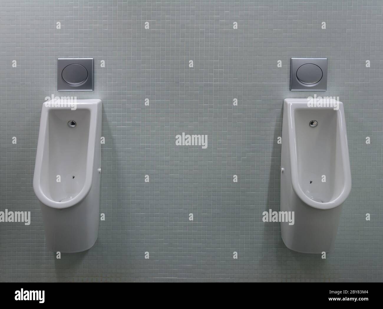 urinals with two white painted a fly on the toilet Stock Photo Alamy