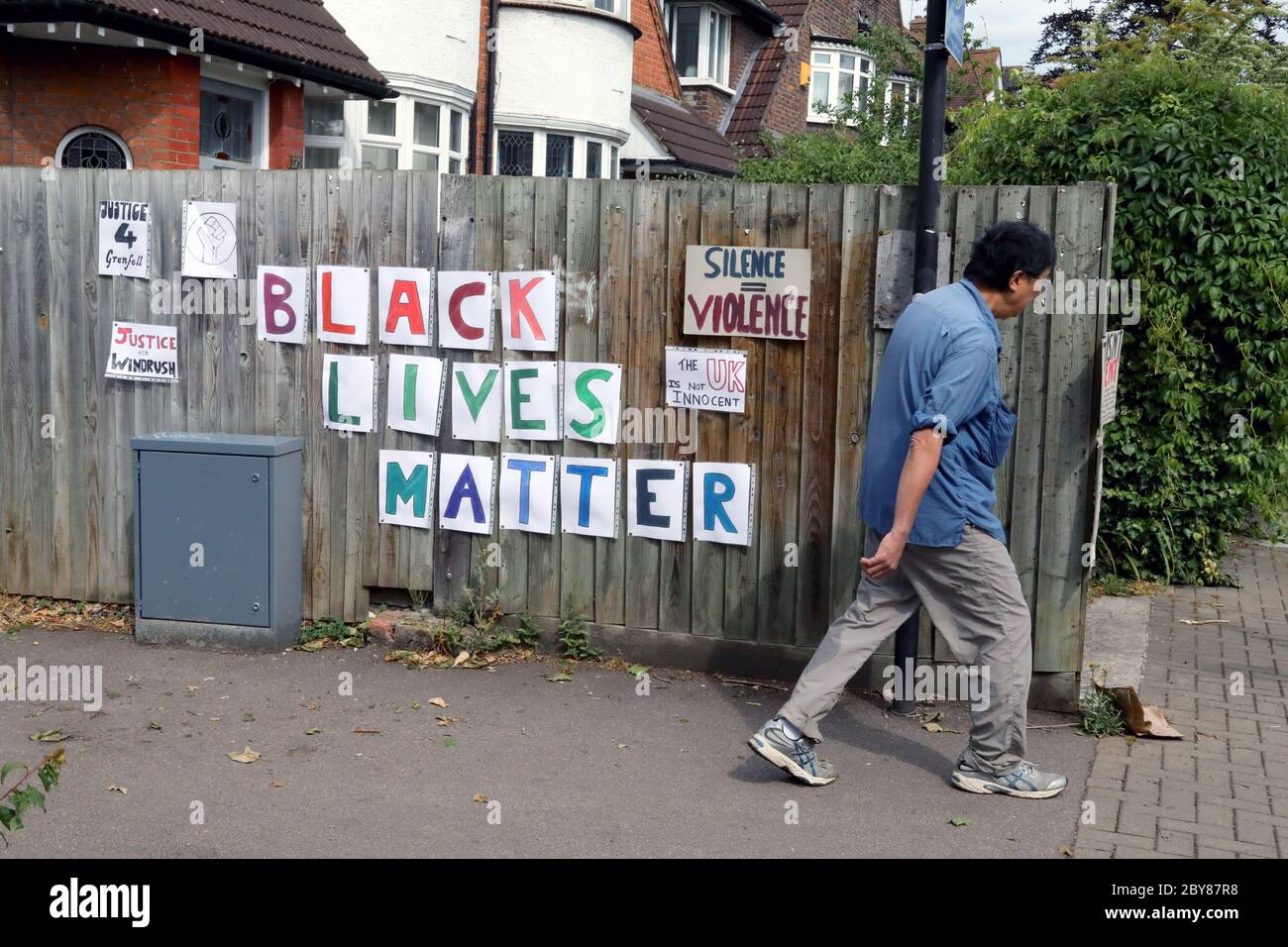 London / UK – June 7, 2020: a man walks past signs for the Black Lives Matter movement in Crouch End, north London Stock Photo
