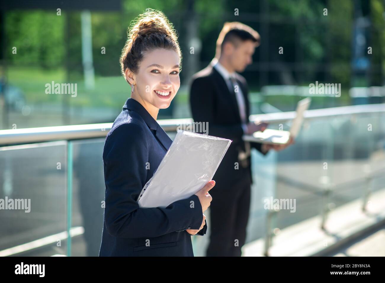 Bright lovely girl with documents standing on the street. Stock Photo