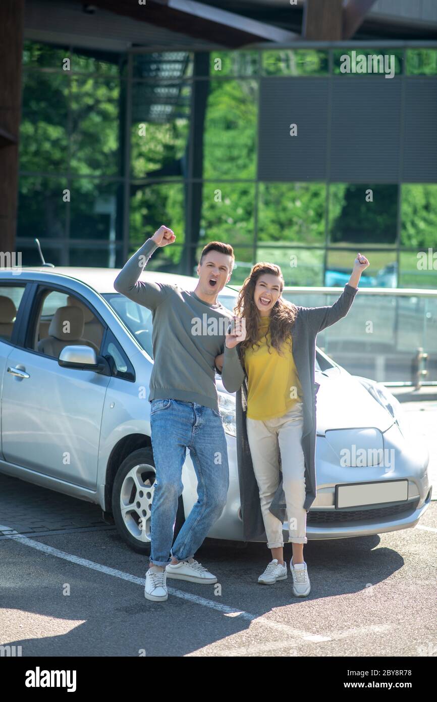 Happy cheerful man and woman near car outdoors Stock Photo - Alamy