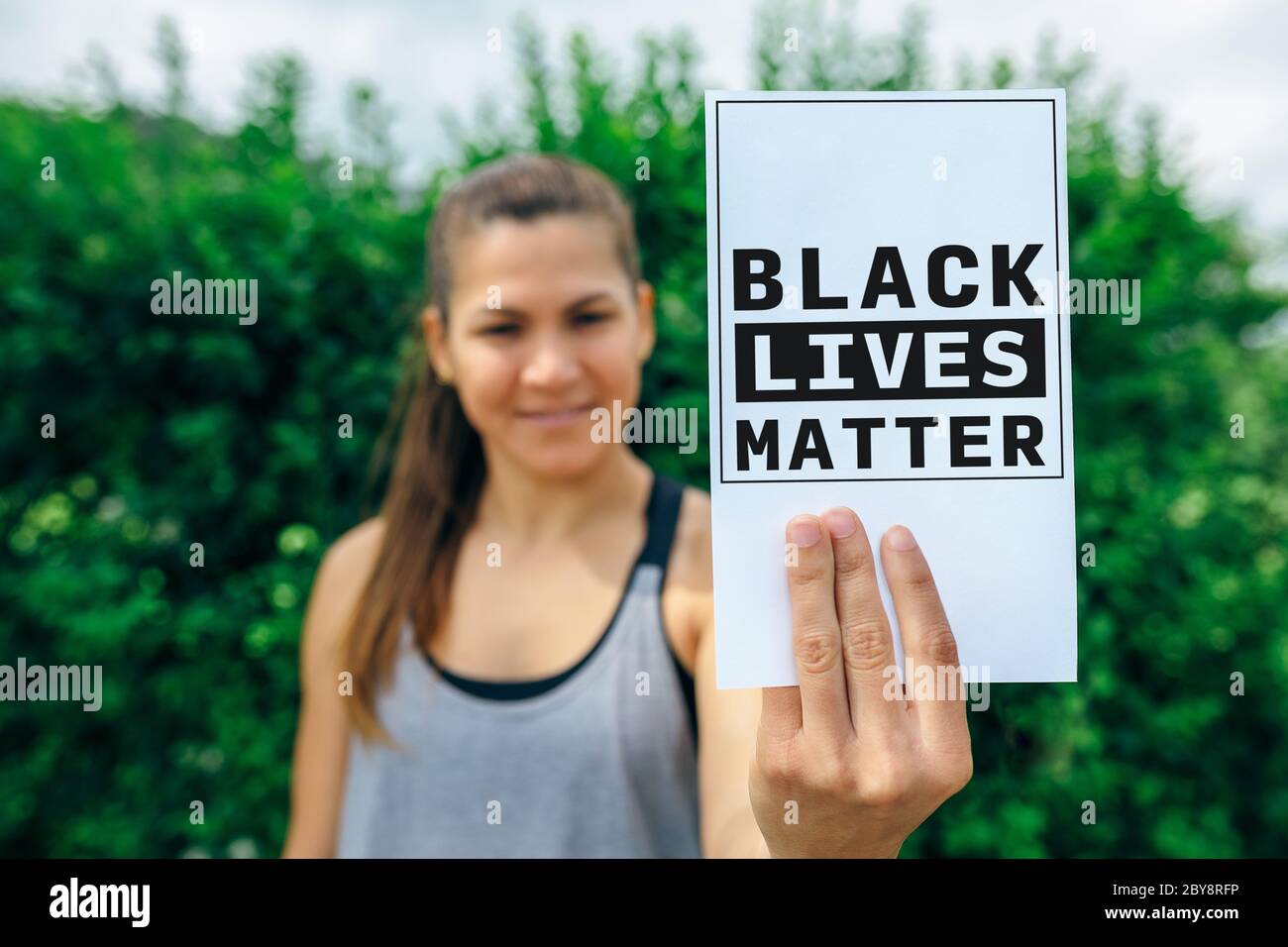 Woman showing card against racism Stock Photo