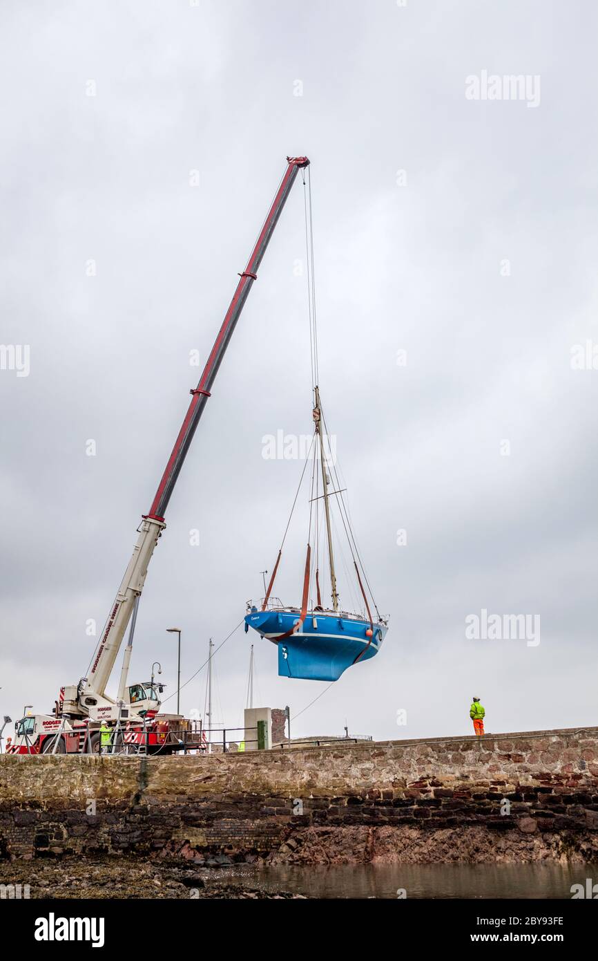 Crane Liftting Boat, Dunbar, East Lothian, Scotland Stock Photo