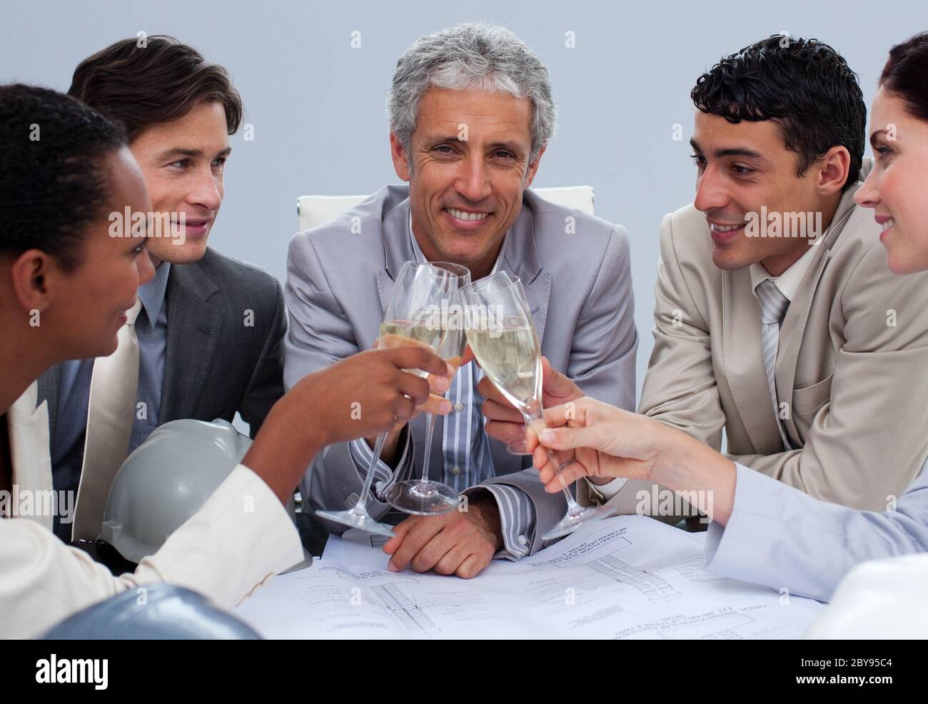 Happy engineer team celebrating a success with champagne Stock Photo