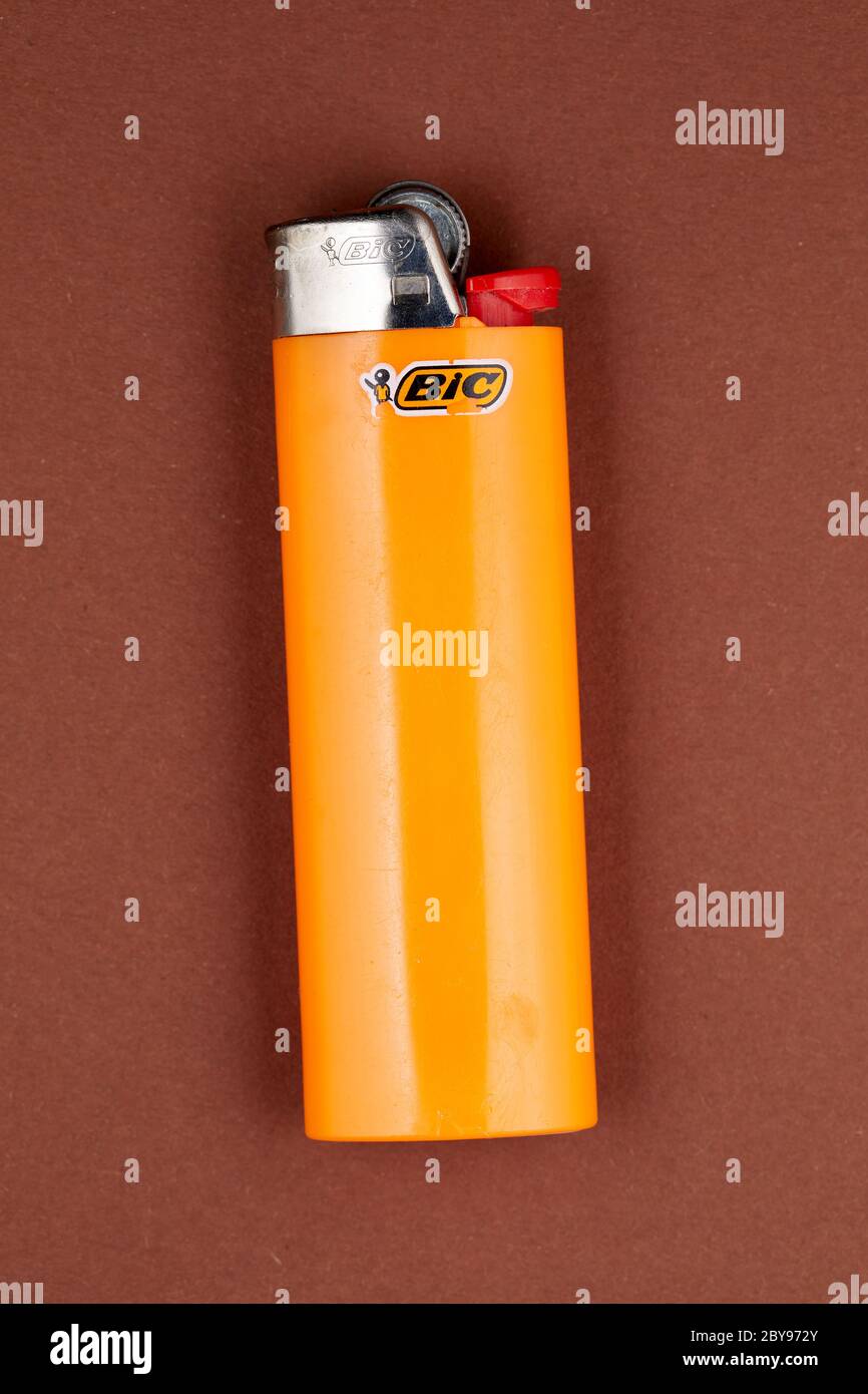 Orange plastic lighter (Bic) on brown background Stock Photo