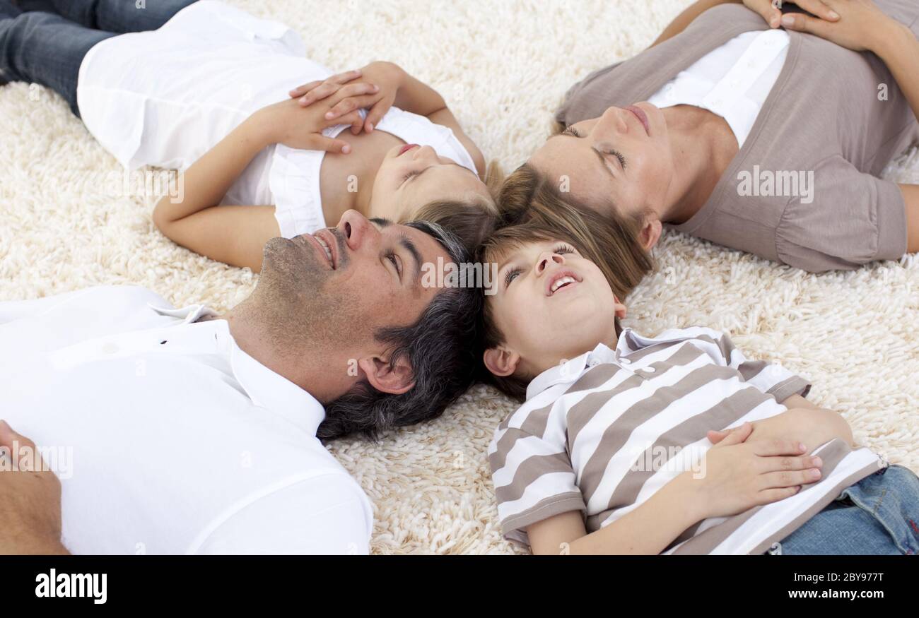 Family lying on floor at home with heads together Stock Photo Alamy