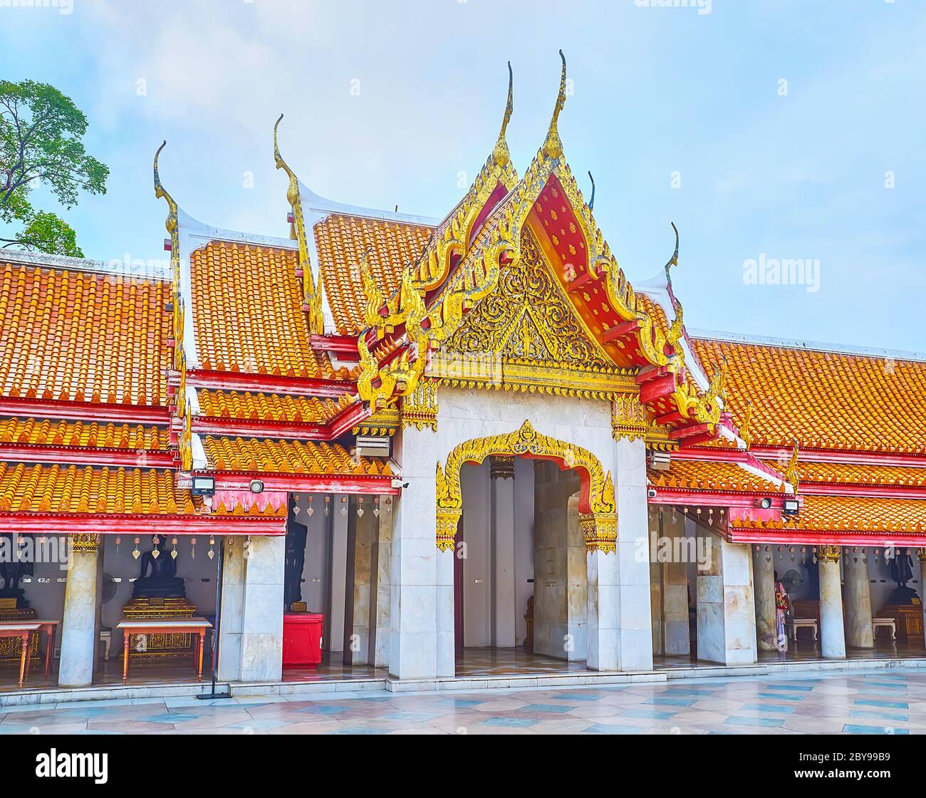 BANGKOK, THAILAND - MAY 13, 2019: The complex pyathat roof of the gallery with gilt and mirror decors, carvings and curved finials, Wat Benchamabophit Stock Photo