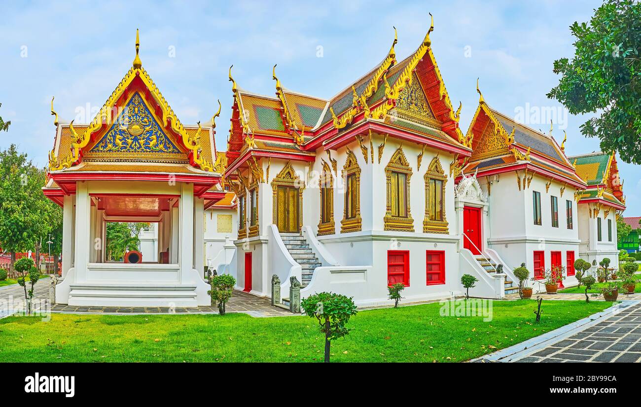 Panorama of Four Princess pavilion of Wat Benchamabophit Dusitvanaram Marble Temple, surrounded with juicy lawn and topiary trees, Bangkok, Thailand Stock Photo