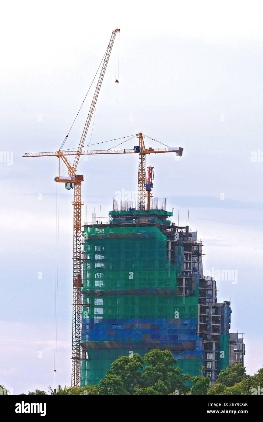 Skyscraper Office Tower Under Construction with two Cranes in Pattaya Thailand Stock Photo