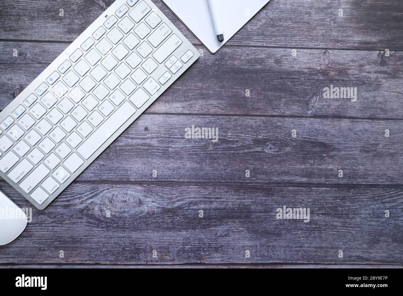 high angle view of keyboard, notepad and computer mouse on table  Stock Photo