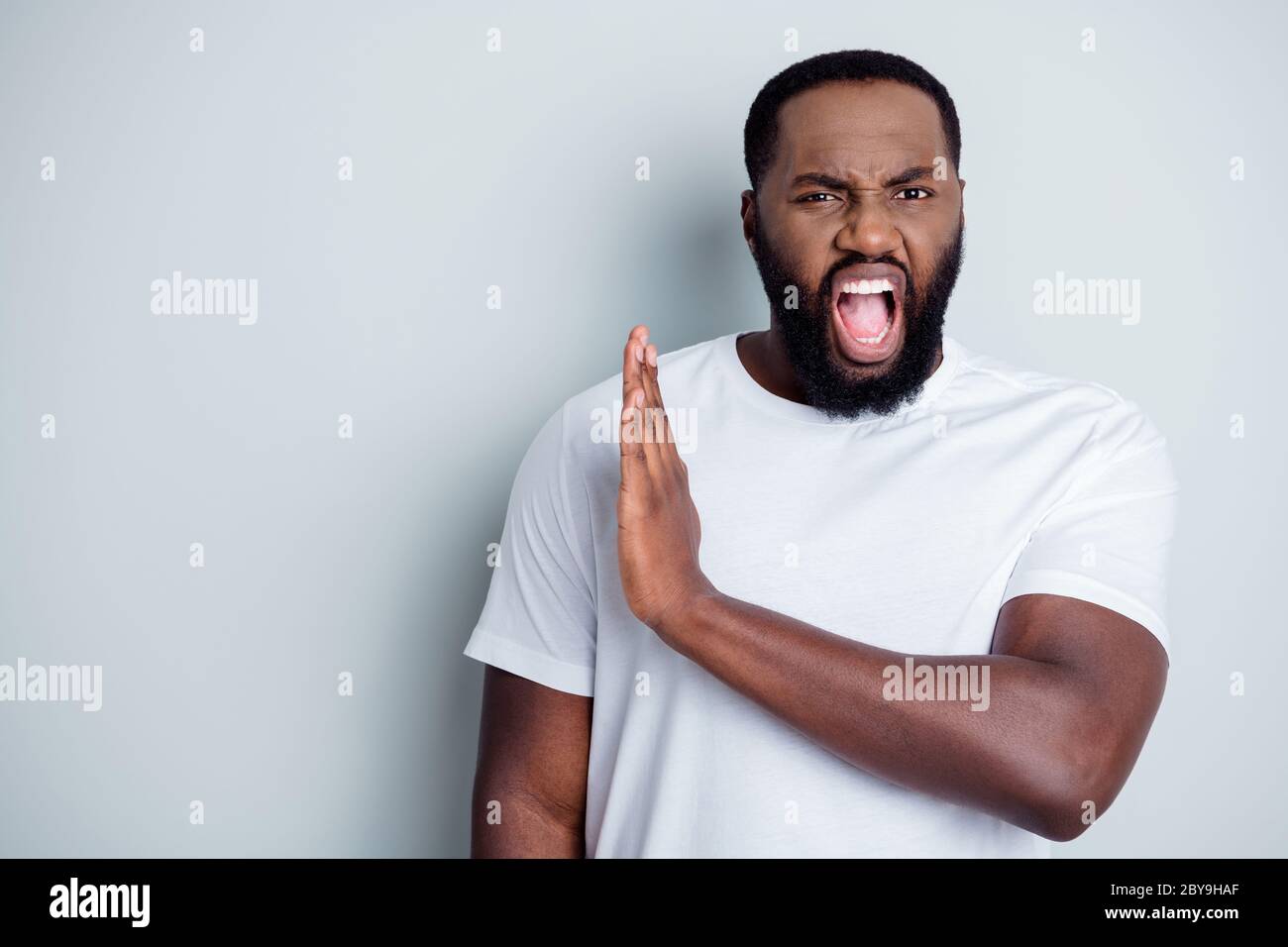 Photo of crazy disappointed yell dark skin african guy antiracism group member leader say no violence behavior black lawlessness raise arm empty space Stock Photo