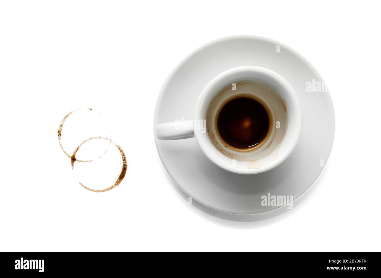 Dirty empty white coffee cup on saucer, two brown circle coffee stains on white background. Top view. Closeup Stock Photo