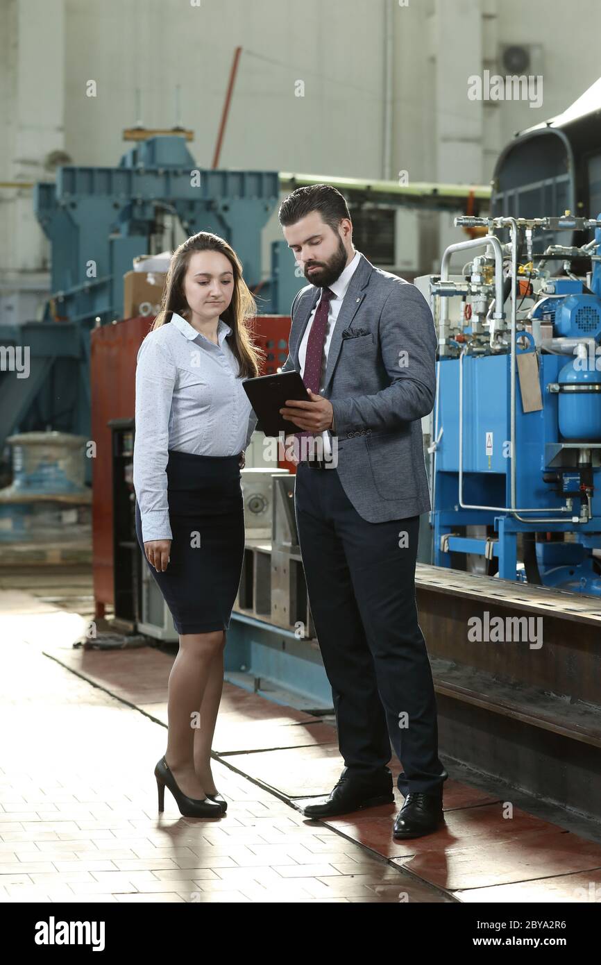 Portrait of a solid businessman with his secretary holding laptop and ...