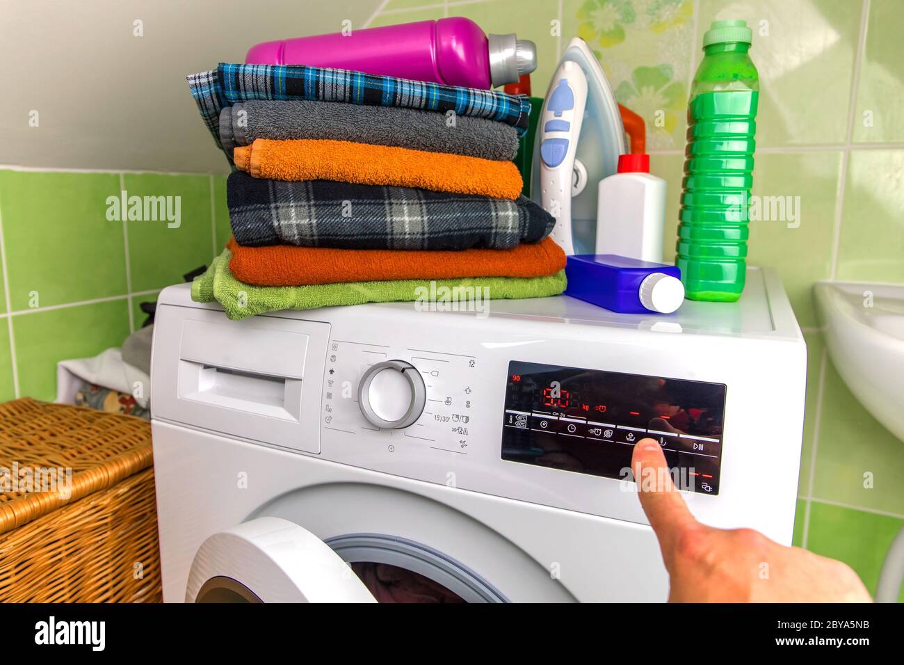 Close Up Of Man Choosing Cycle Program On Washing Machine. Adjusting wash settings on the
