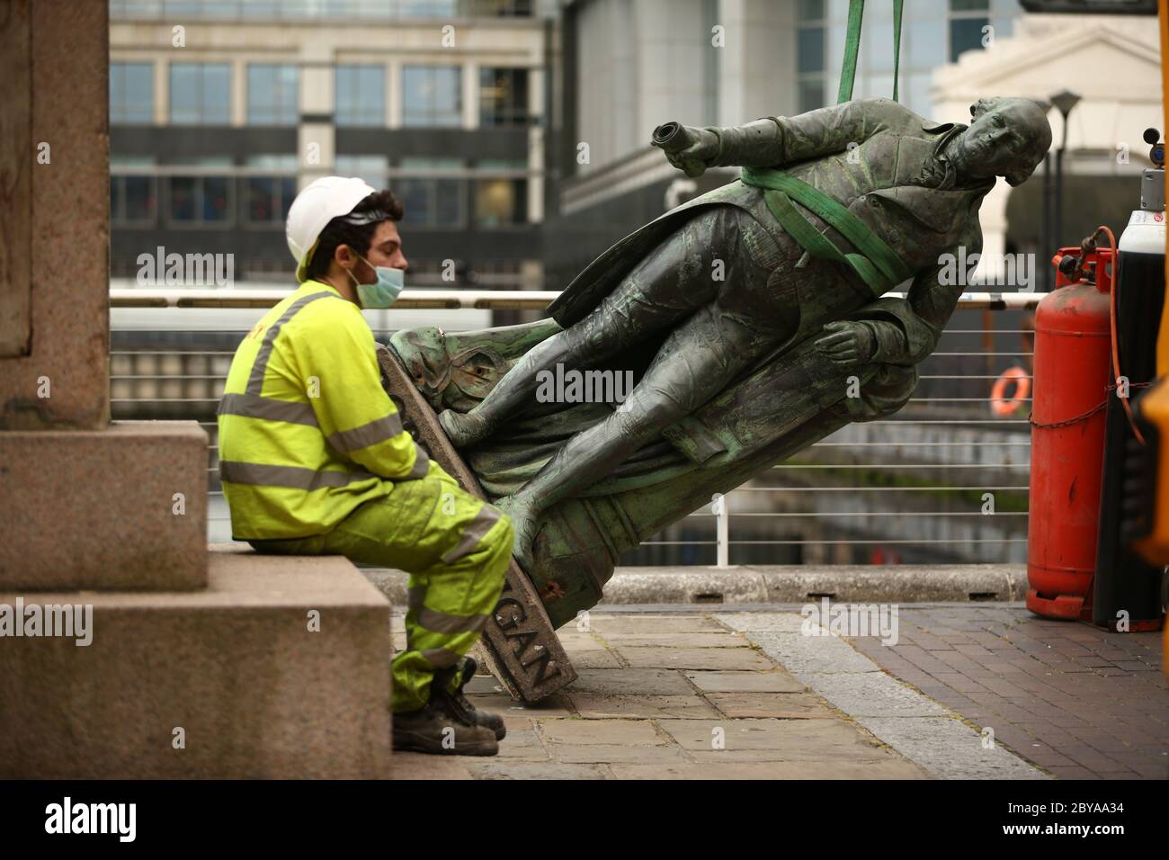 A worker sits down as they take down a statue of slave owner Robert