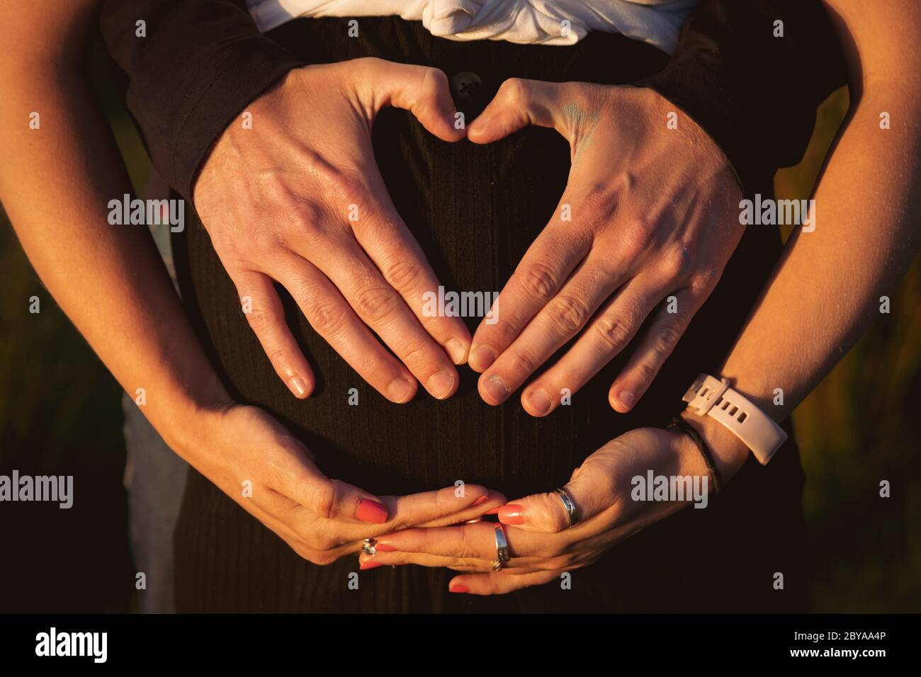 Pregnant couple outside at sunset. Happy family pregnancy Stock Photo