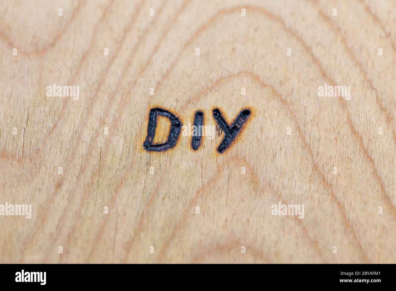 an abbreviation DIY - do it yourself - burned by hand with electrical woodburner on plywood surface Stock Photo