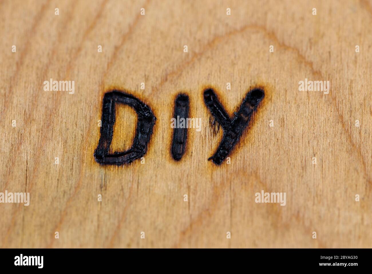 an abbreviation DIY - do it yourself - burned by hand with electrical woodburner on plywood surface Stock Photo