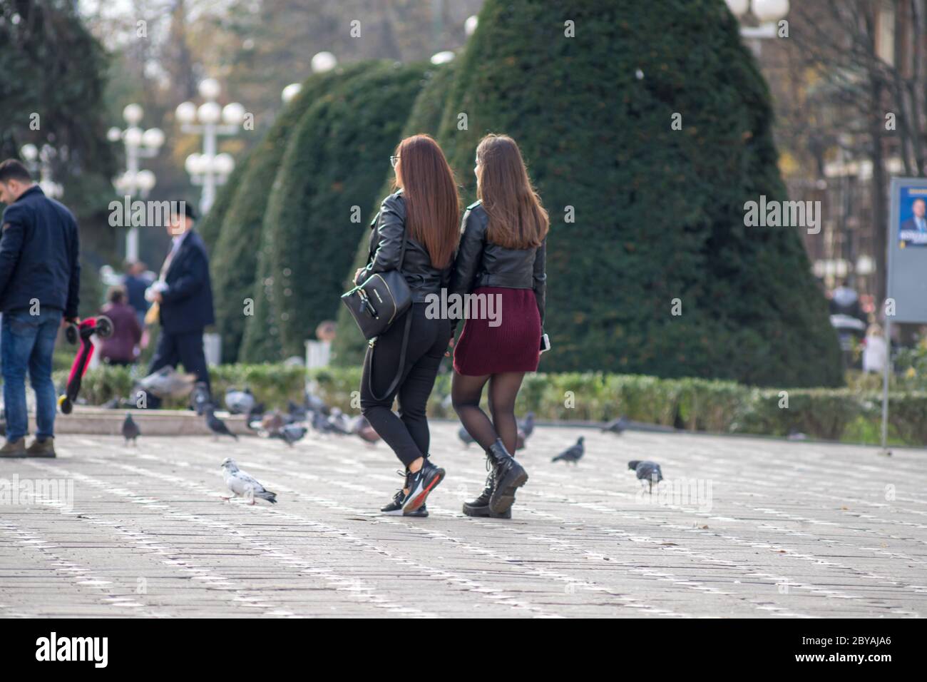Two girls walking on the street. Real people Stock Photo - Alamy