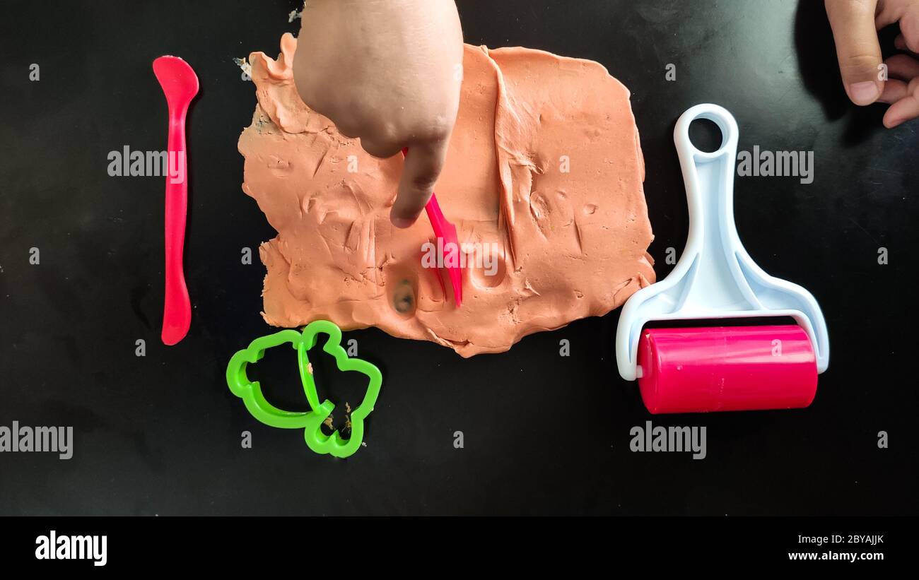 Homemade clay.  Child hands playing with colorful clay. Homemade plastiline. Stock Photo