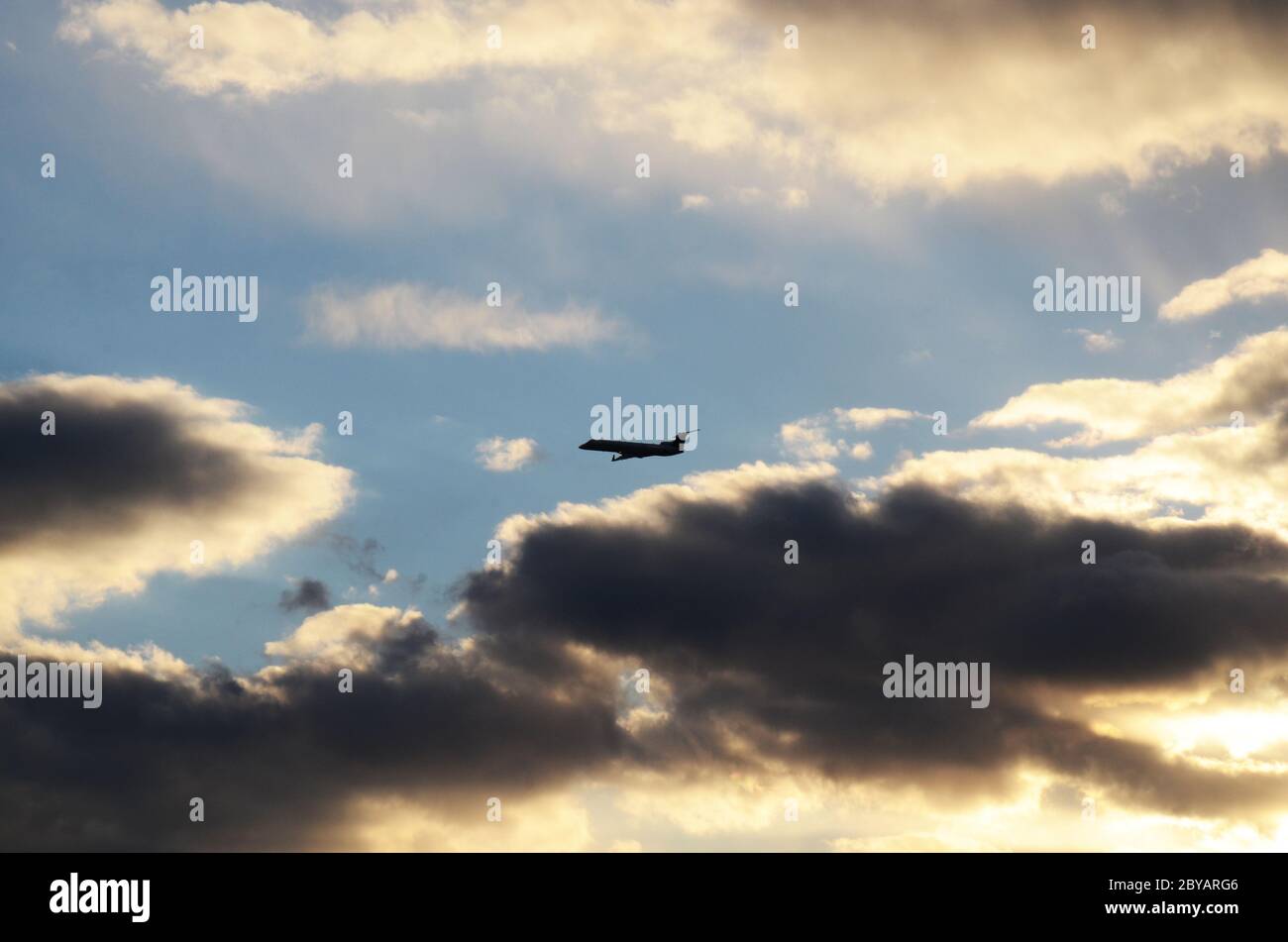 FLIGHT 419: Commercial airliners take off from a nearby Newark International airport in New Jersey into sun setting cloudscape on a spring day. Stock Photo