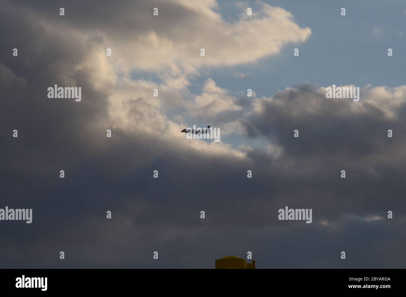 FLIGHT 419: Commercial airliners take off from a nearby Newark International airport in New Jersey into sun setting cloudscape on a spring day. Stock Photo