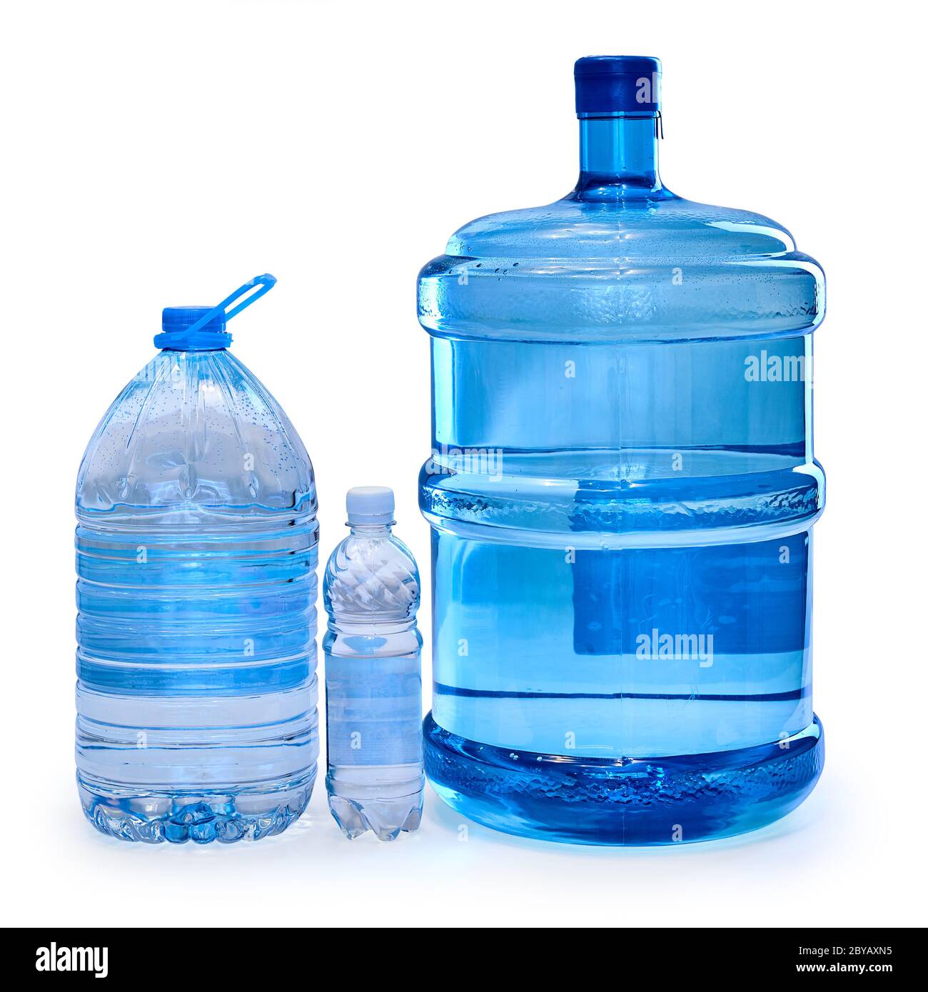 Three blue bottles of different sizes with drinking water isolated on a white background. Stock Photo