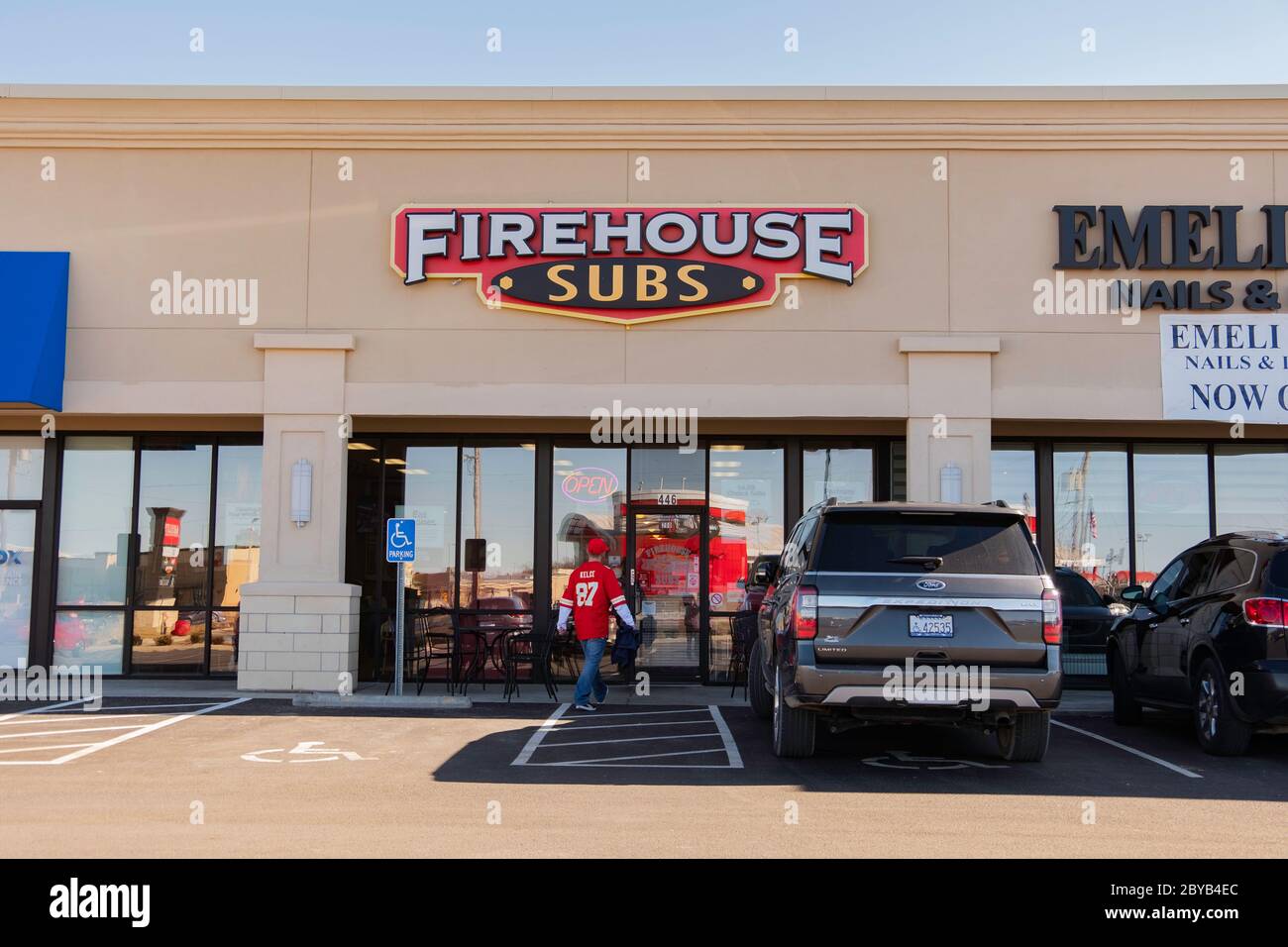 Storefront and entrance of Firehouse Subs in a strip mall with customer entering. Wichita, Kansas, USA. Stock Photo