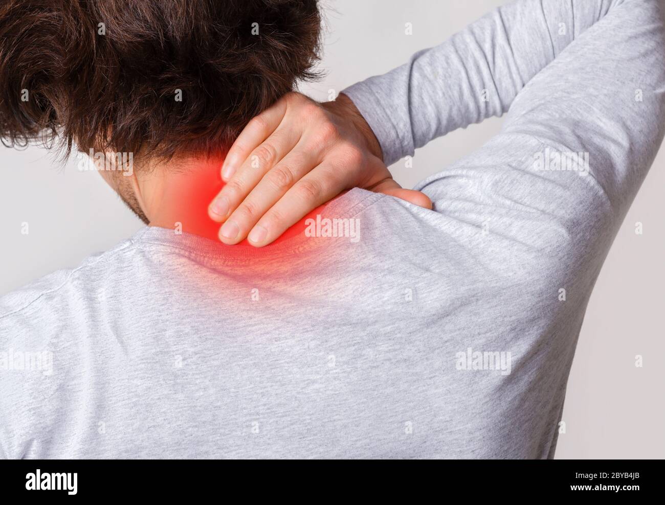 Muscle inflammation in neck. Man holds to sore spot highlighted in red