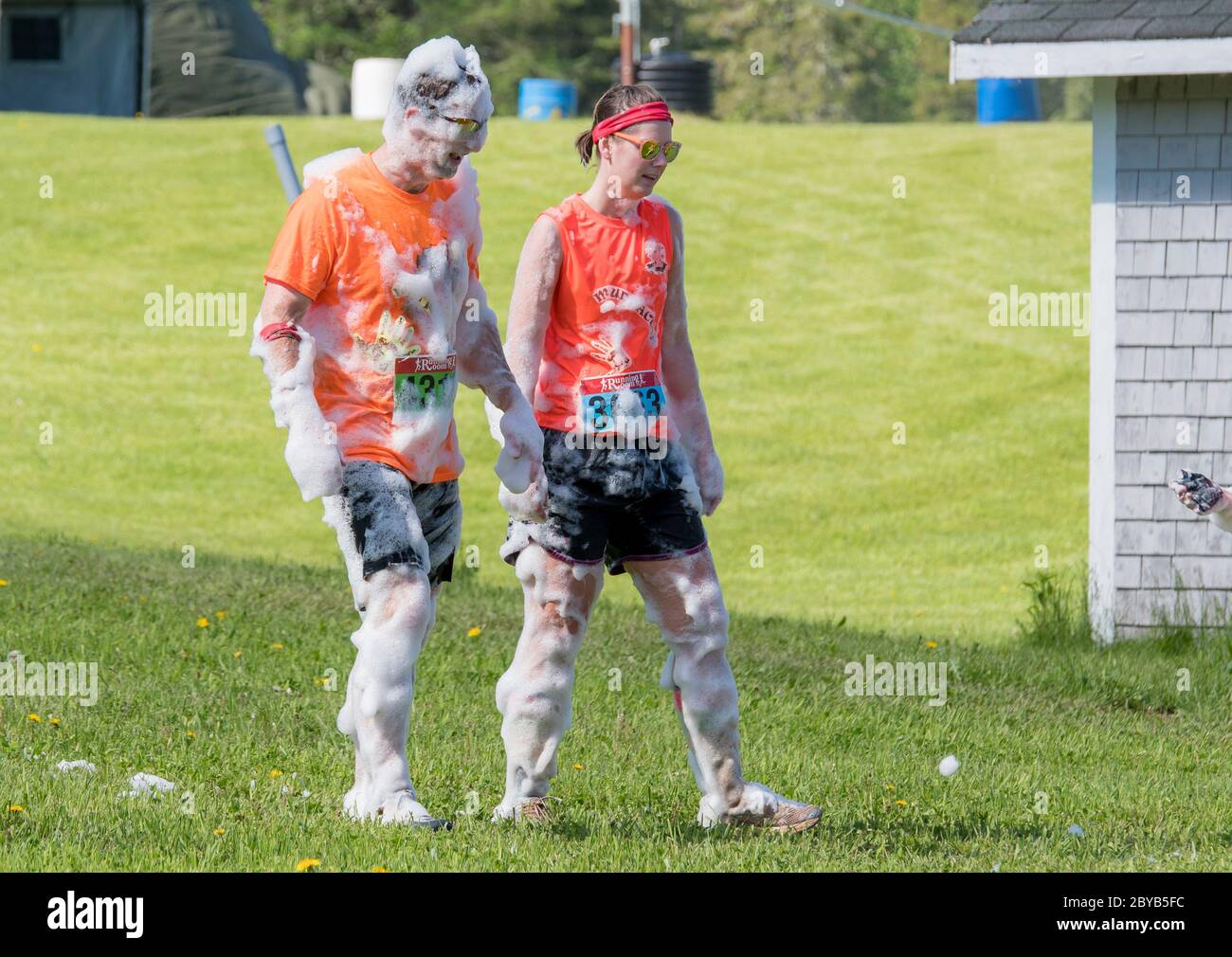 Poley Mountain, New Brunswick, Canada - June 10, 2017: Participating in the annual fundraiser 'Mud Run For Heart'. Two people covered with soap suds. Stock Photo