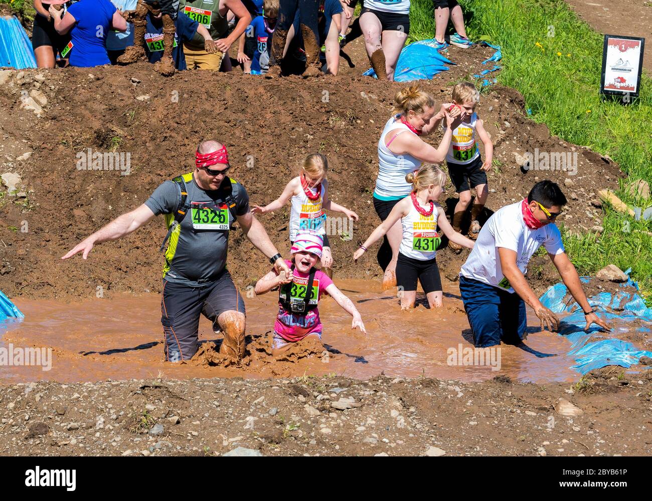 Poley Mountain, New Brunswick, Canada - June 10, 2017: Participating in the annual fundraiser 'Mud Run For Heart'. People wade through mus and water. Stock Photo