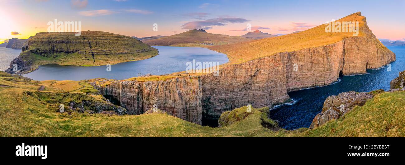 Leitisvatn lake and Tralanipan, slave rock at sunset. Vagar island, Faroe Islands. Denmark Stock Photo