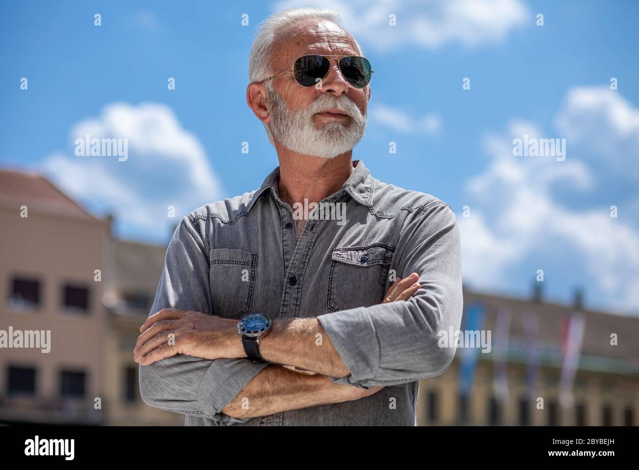 Experienced rich senior old man with beard and sunglass on street