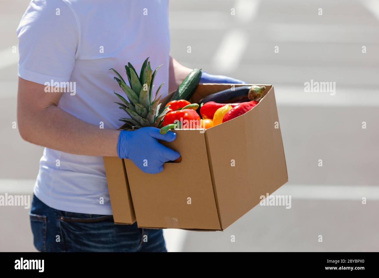 Courier with medical gloves delivers takeaway food.        Delivery service under quarantine, disease outbreak, coronavirus covid-19 pandemic conditio Stock Photo