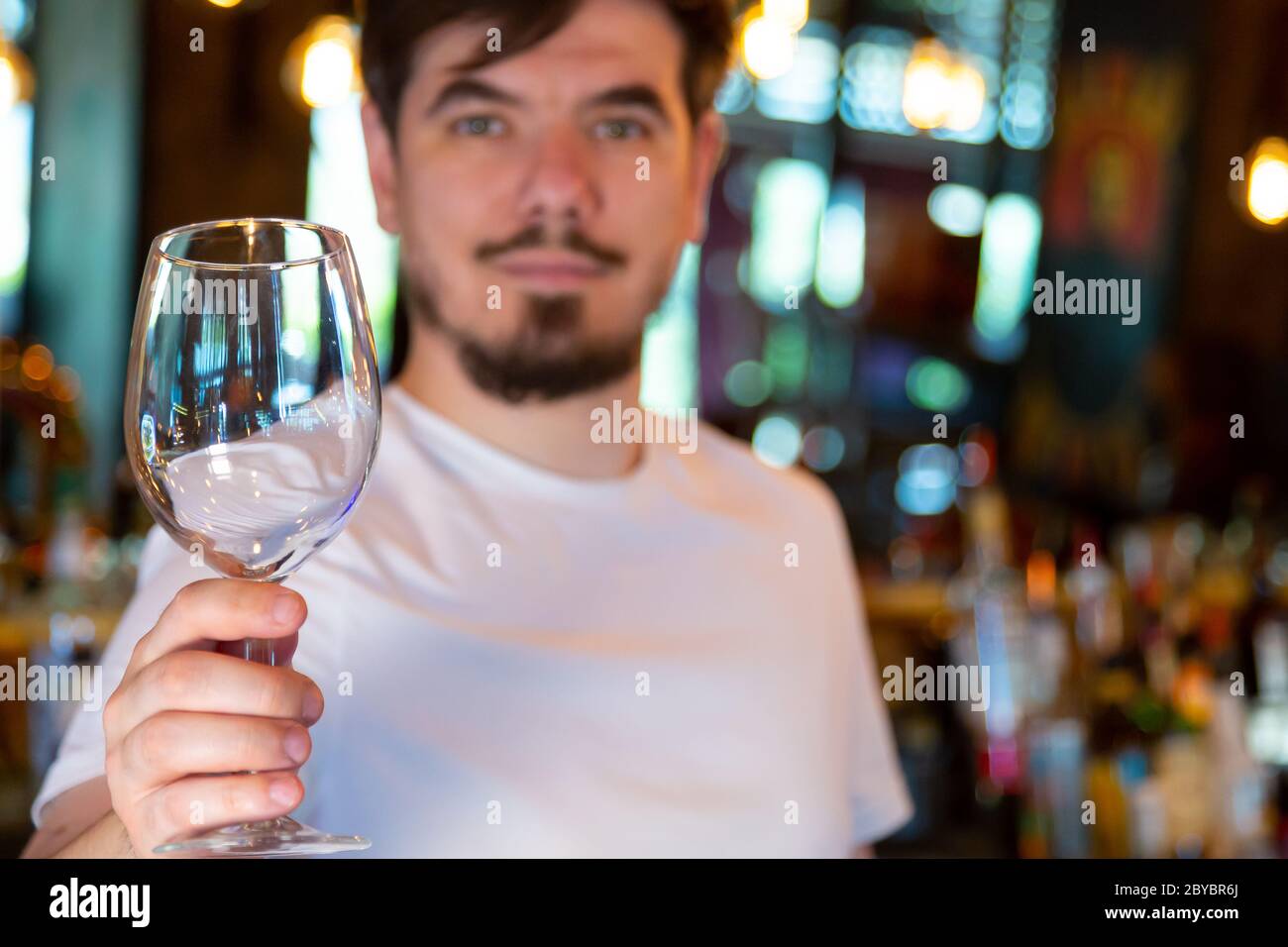 Young Bartender at the Bar with a Glass in his Hand Stock Photo