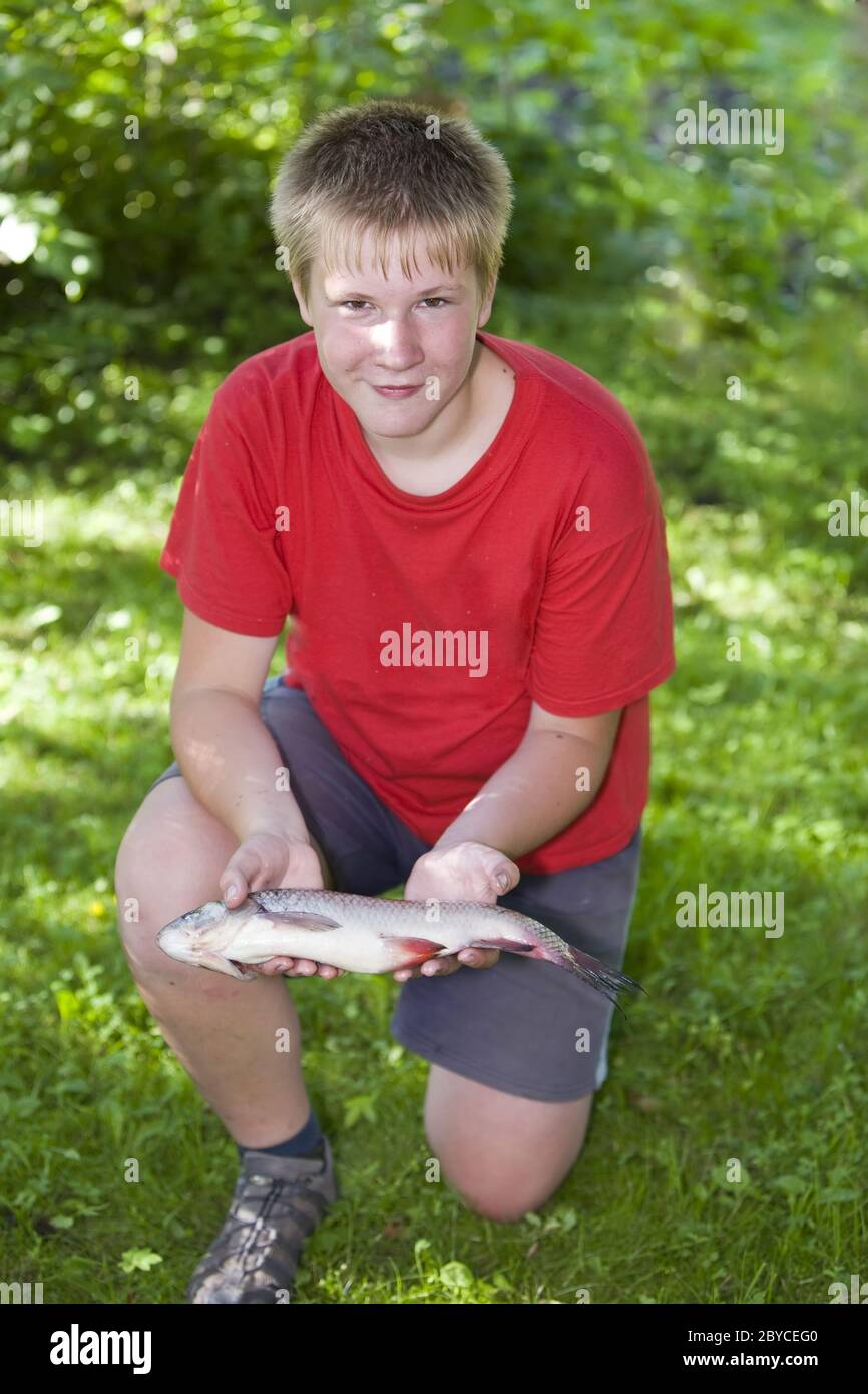 Teenager with caught fish Stock Photo Alamy