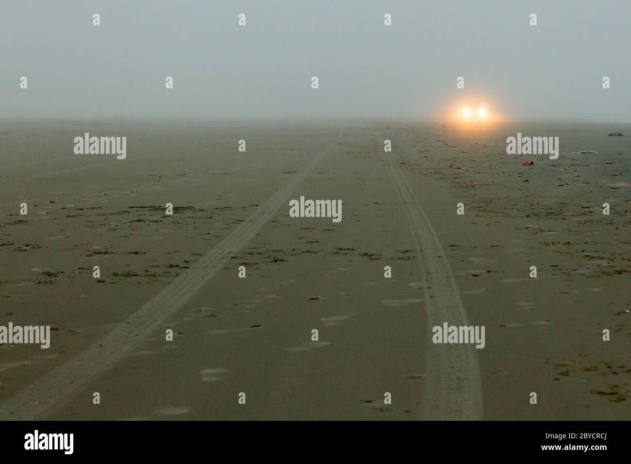 Car headlights of a car on the beach Stock Photo
