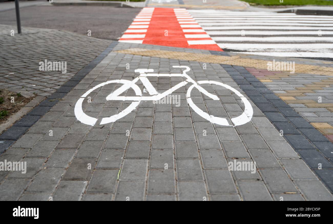 Cycling path with a symbol of bike on a ground through avtomobile road. Bike  path in a modern city Stock Photo - Alamy