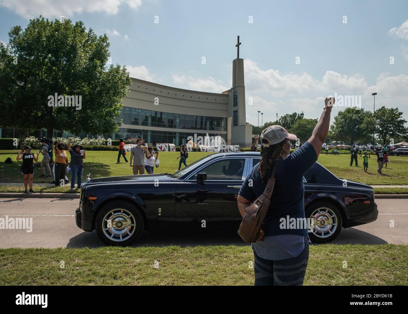 Houston, United States. 09th June, 2020. A woman raises her fist in salute as the funeral procession carrying the body of George Floyd to Houston Memorial Gardens passes the Fountain of Praise church in Houston, Texas on Tuesday, June 9, 2020. George Floyd died in police custody in Minneapolis, Minnesota on May 25, 2020. His death sparked demonstrations globally to combat racism and legislation in Congress for reforms. Photo by Jemal Countess/UPI Credit: UPI/Alamy Live News Stock Photo