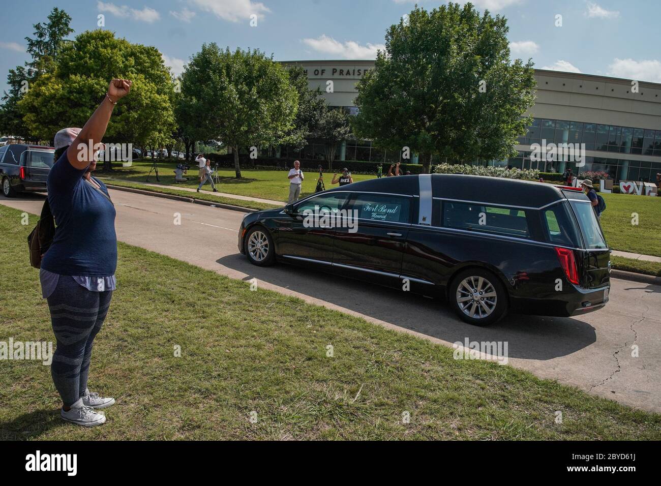 Houston, United States. 09th June, 2020. A woman raises her fist in salute as the Hearse carrying the body of George Floyd to Houston Memorial Gardens passes the Fountain of Praise church in Houston, Texas on Tuesday, June 9, 2020. George Floyd died in police custody in Minneapolis, Minnesota on May 25, 2020. His death sparked demonstrations globally to combat racism and legislation in Congress for reforms. Photo by Jemal Countess/UPI Credit: UPI/Alamy Live News Stock Photo