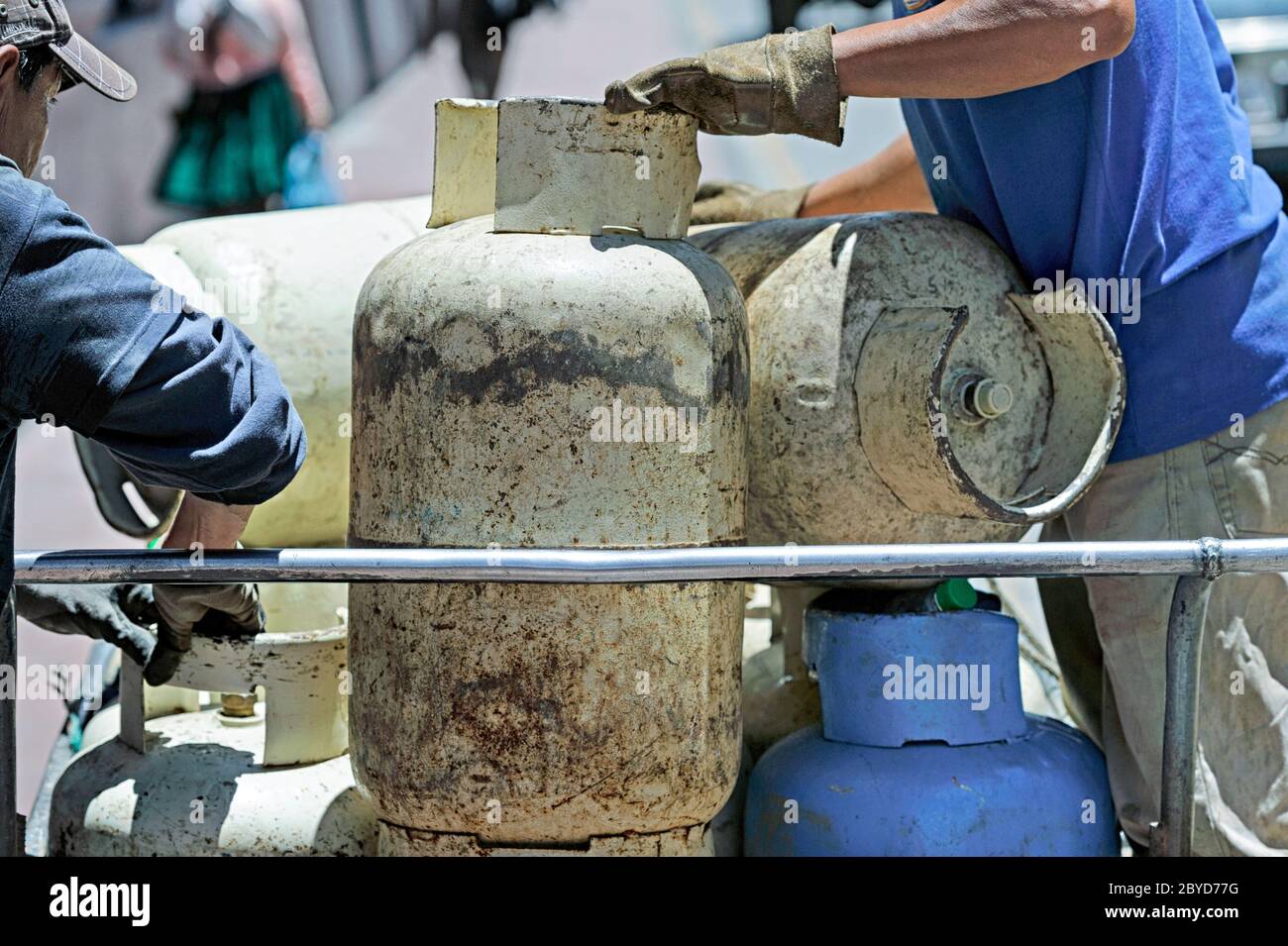 Large propane tanks being delivered to commercial businesses in downtown Cuenca Ecuador by bicycle transportation Stock Photo