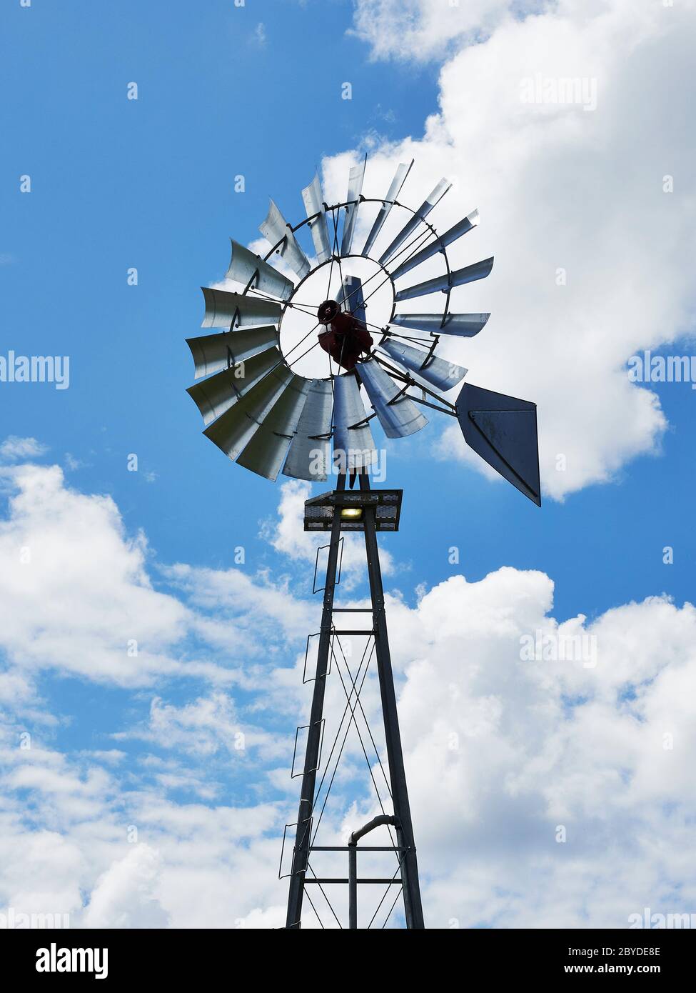 Old farm or ranch windmill water pump pumping water for agriculture in rural Alabama, USA . Stock Photo