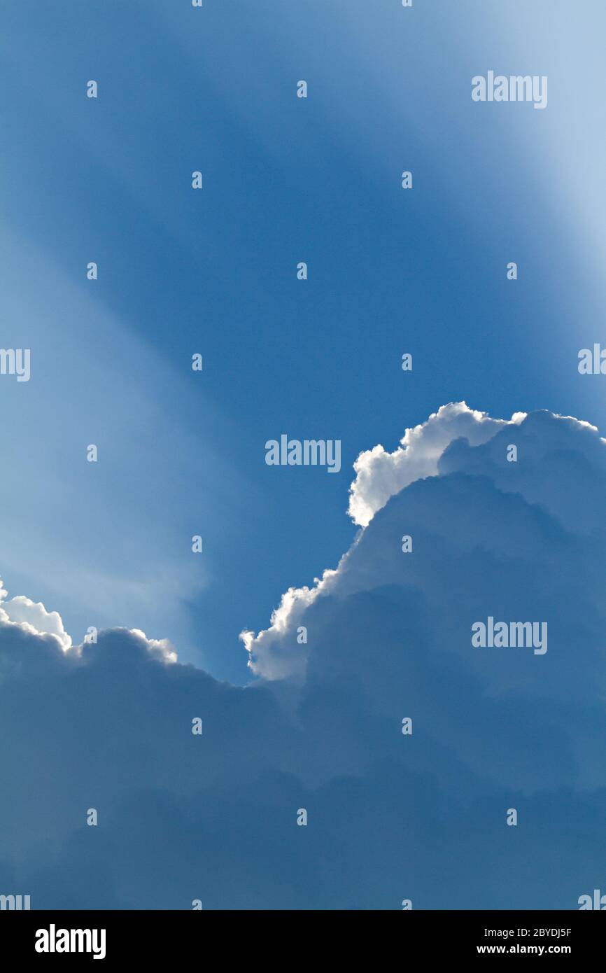 sunlight shining through layers of clouds Stock Photo