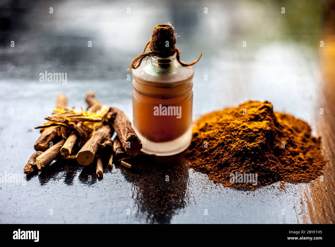 Shot of Rheum emodi or Revand Chini along with its oil and raw powder on a black glossy surface. Stock Photo