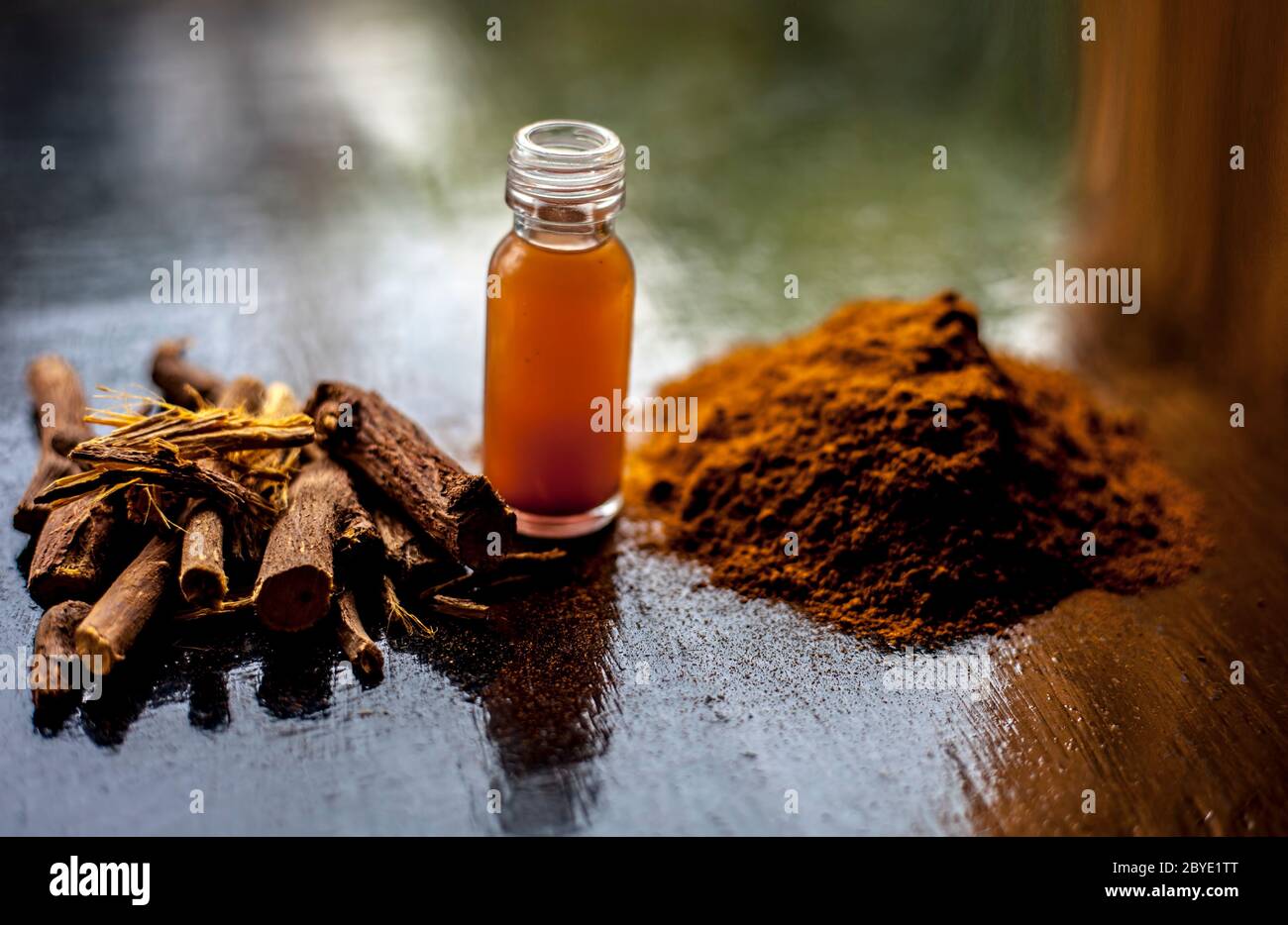 Shot of Rheum emodi or Revand Chini along with its extracted root essence and raw powder on a black glossy surface. Stock Photo