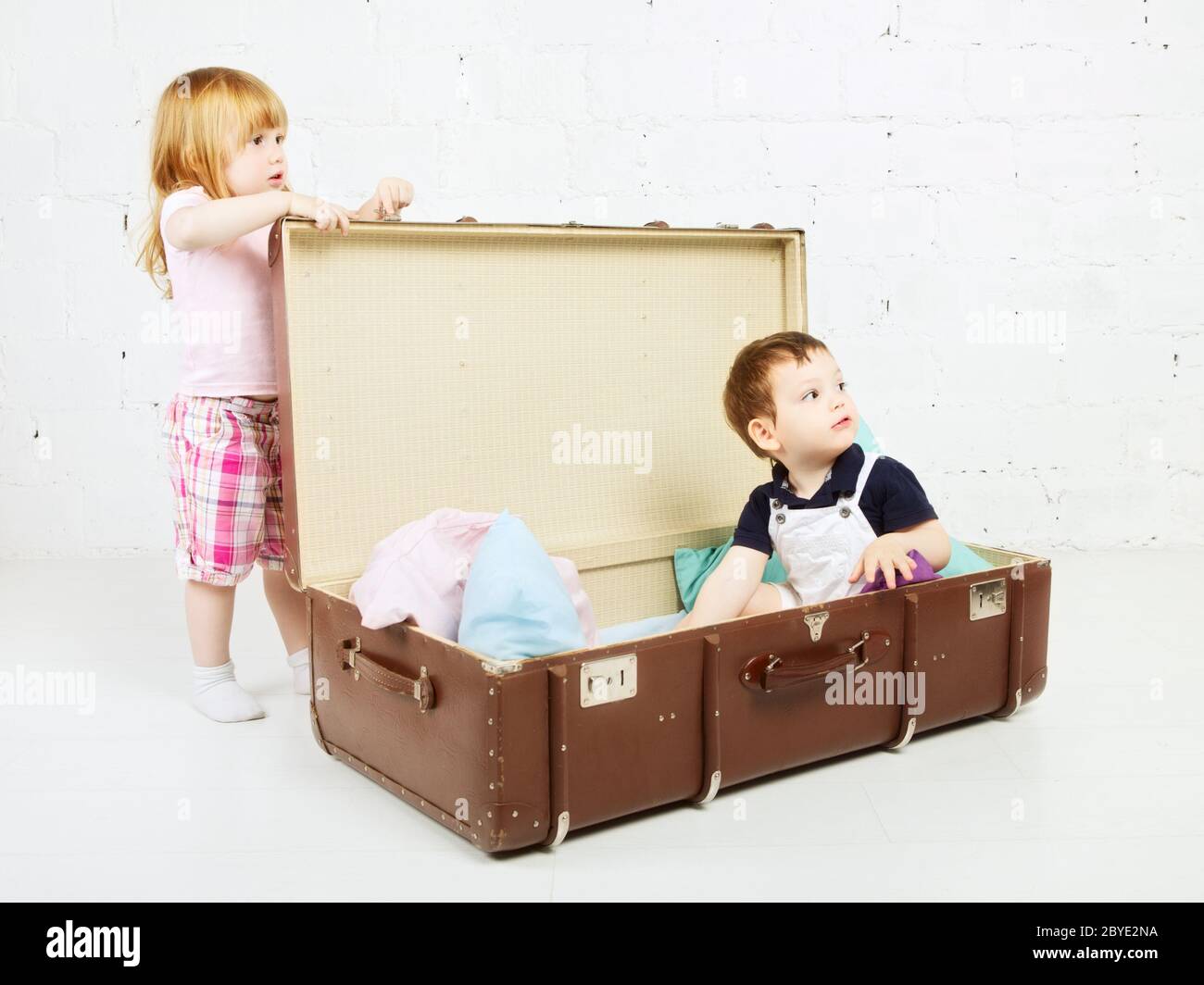 Boy and Girl in Suitcase Stock Photo