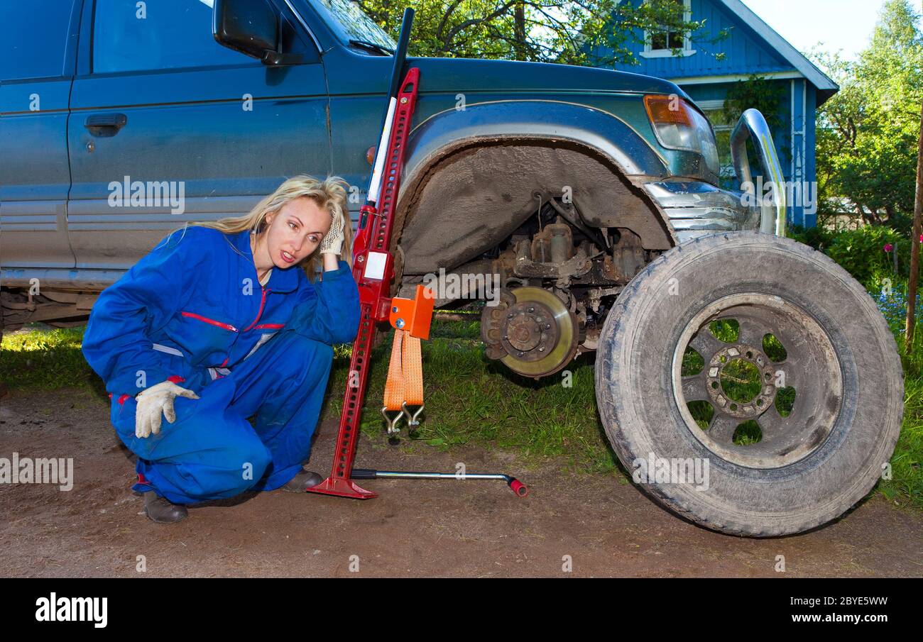 The woman in working overalls tries to replace a w Stock Photo - Alamy