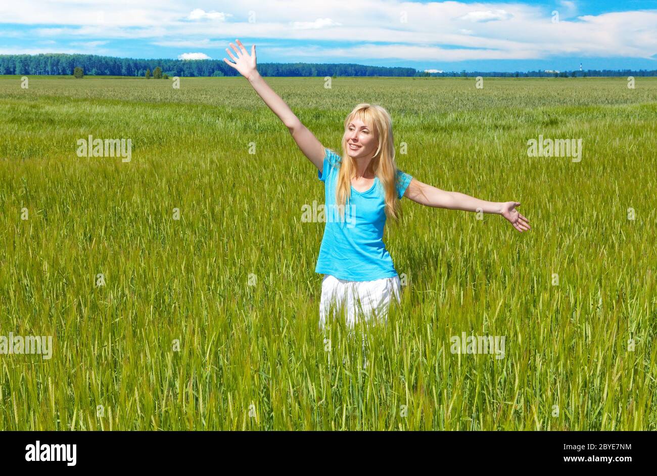 young woman in the field of green ears Stock Photo