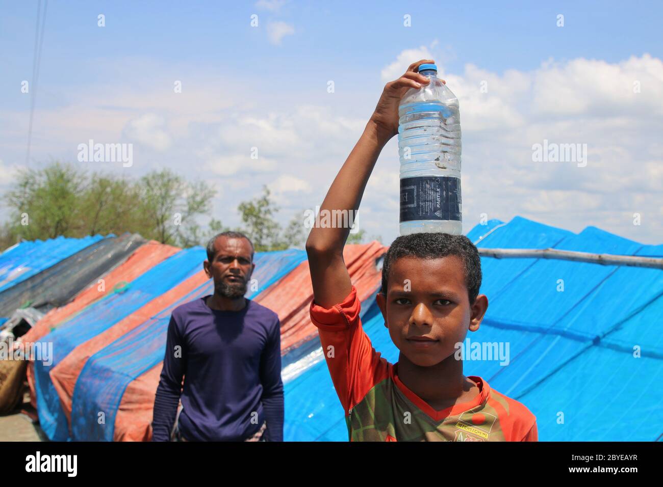 Indian boy carrying water bottle hi-res stock photography and