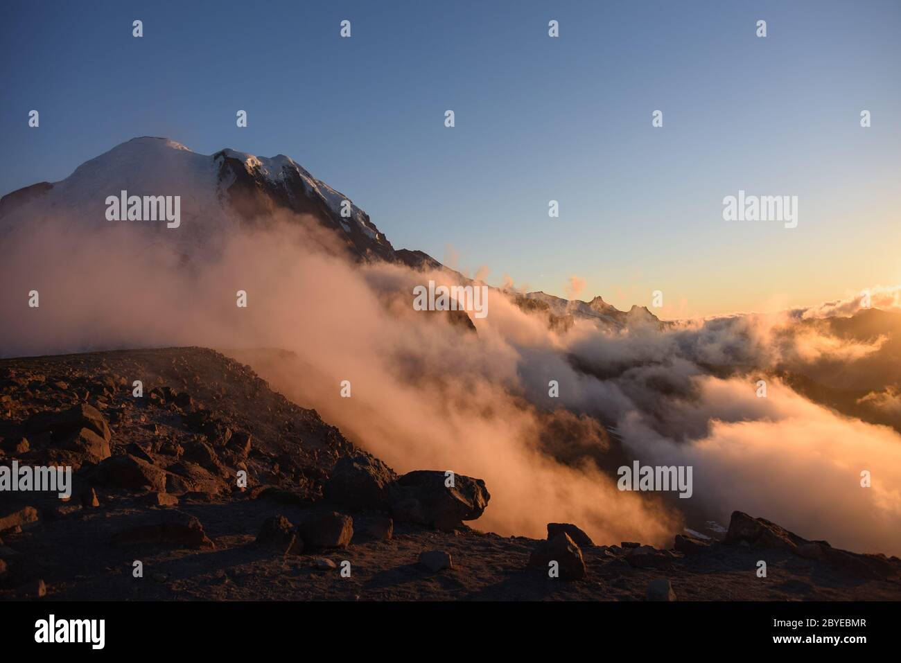Top of a cliff and mountain peak with rolling clould. Mount Rainier National Park, Washington, at sunset. Stock Photo